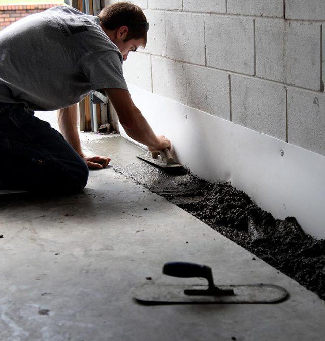 A Man Fixing a Basement Floor